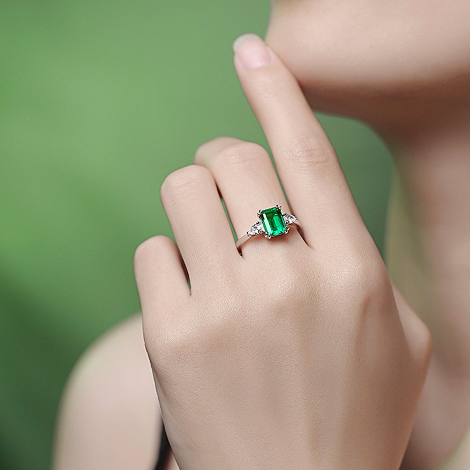 Model wearing a minimalist princess cut lab grown emerald ring, showing the adjustable open band fit.