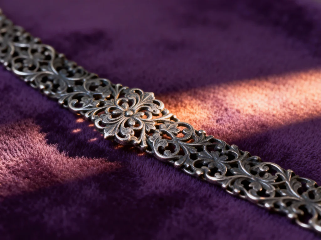 Detailed close-up of an antique platinum bracelet with a rich patina highlighting its filigree work.