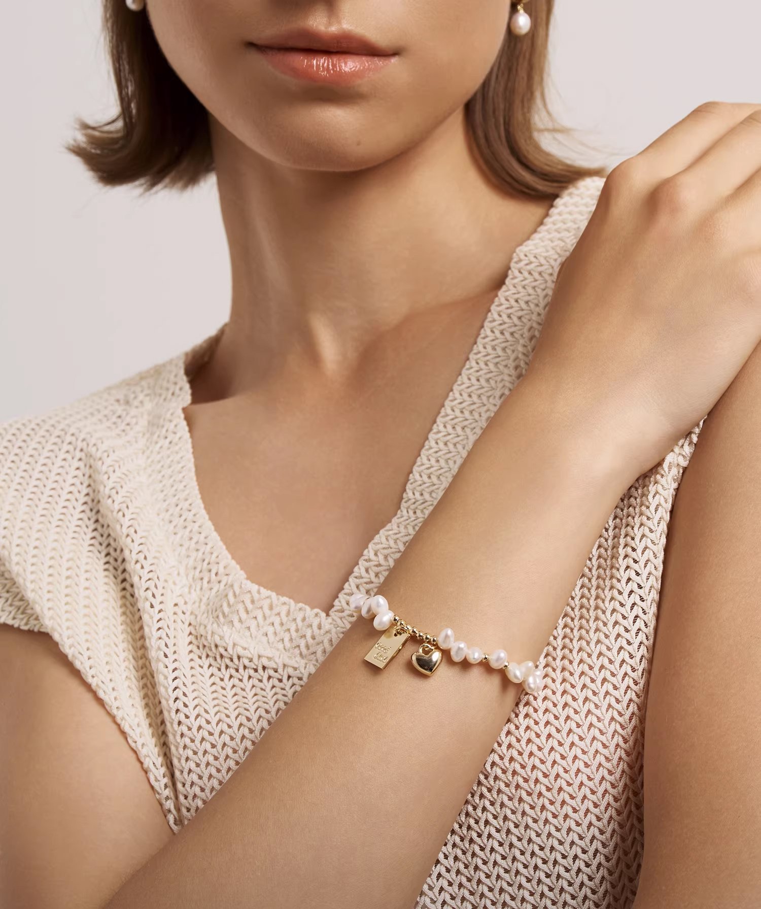 Freshwater pearl gold charm bracelet on wrist – adjustable extender chain