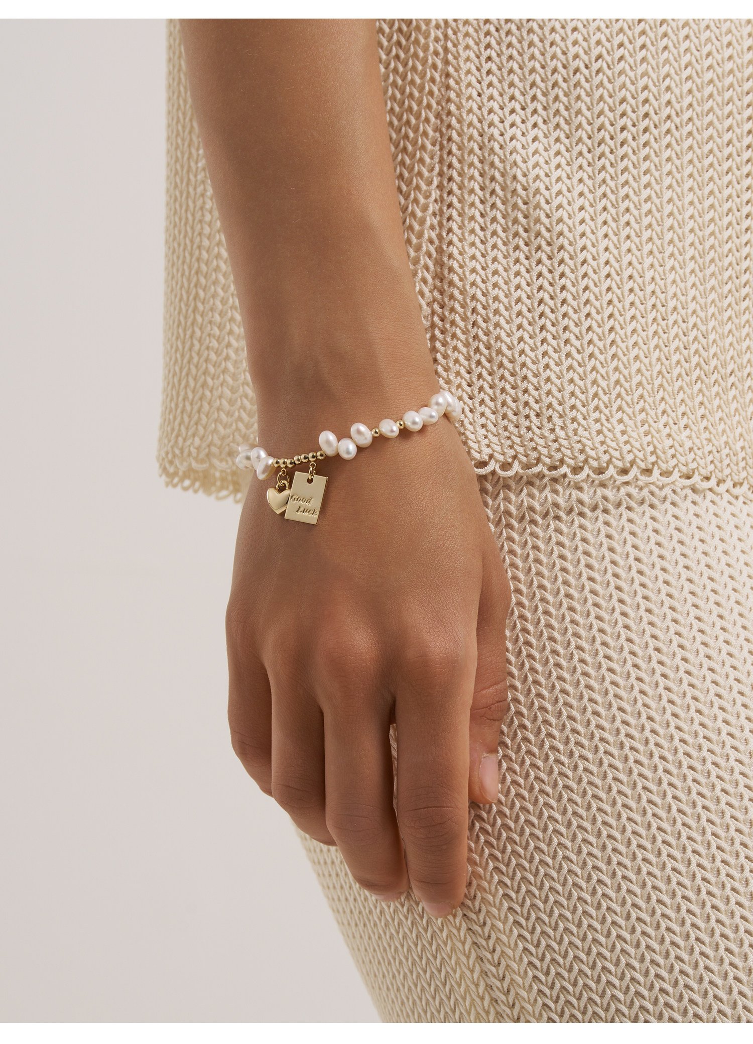 Freshwater pearl gold charm bracelet on wrist – adjustable extender chain