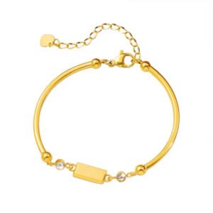 18K gold plated bar bracelet on clean white background, featuring minimalist gold brick charm engraved with "GOLD" and sparkling cubic zirconia stones, delicate chain, SYMARA jewelry for everyday elegance.