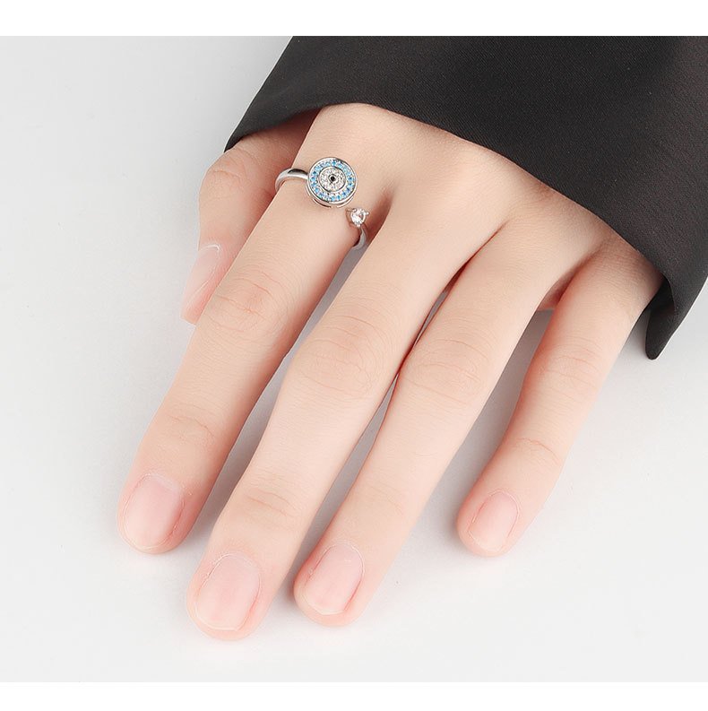 Woman wearing Evil Eye Spinning Ring, open adjustable S925 silver ring, blue cubic zirconia evil eye design