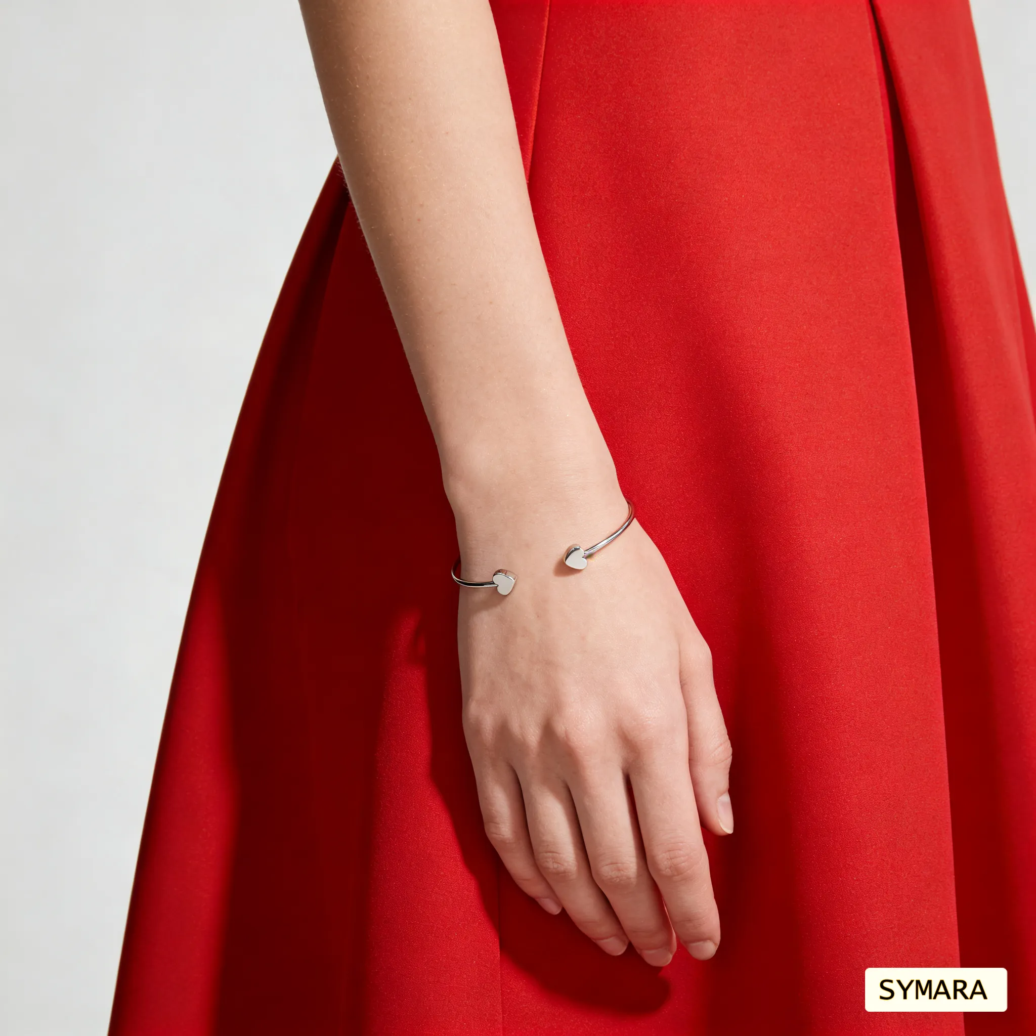 SYMARA classic heart bangle on wrist, White gold plated, catching natural light