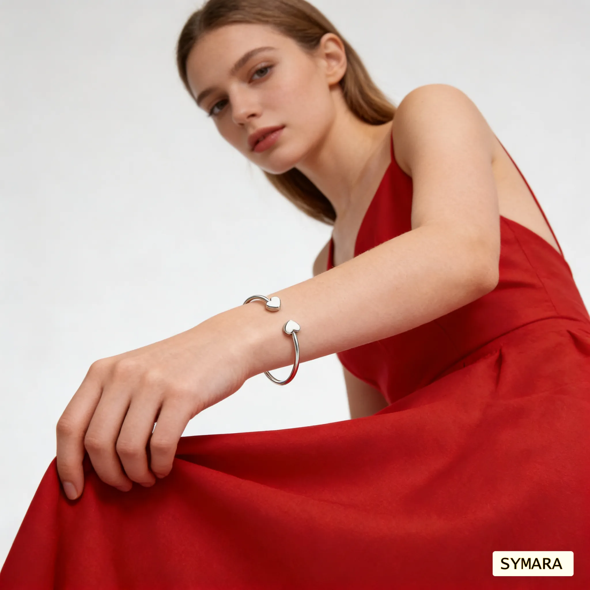 SYMARA classic heart bangle on wrist, White gold plated, catching natural light