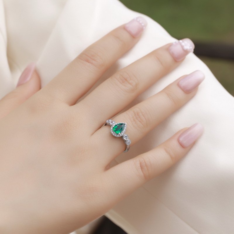 Model wearing SYMARA women’s pear-shaped lab grown emerald ring on finger 