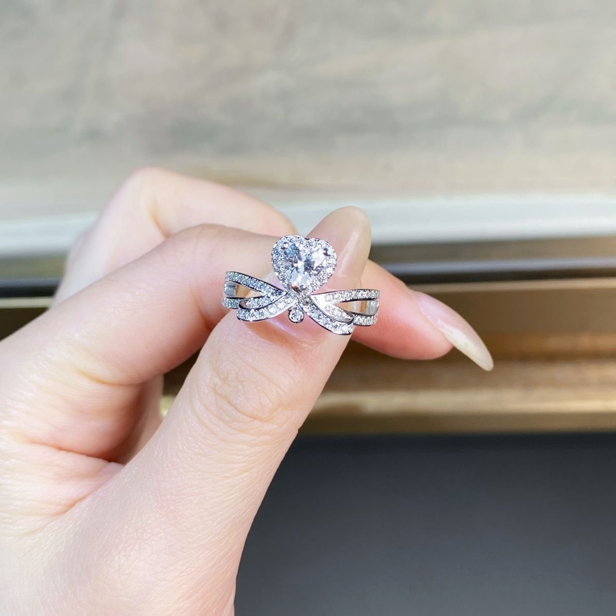 Women’s minimalist heart moissanite ring worn on finger