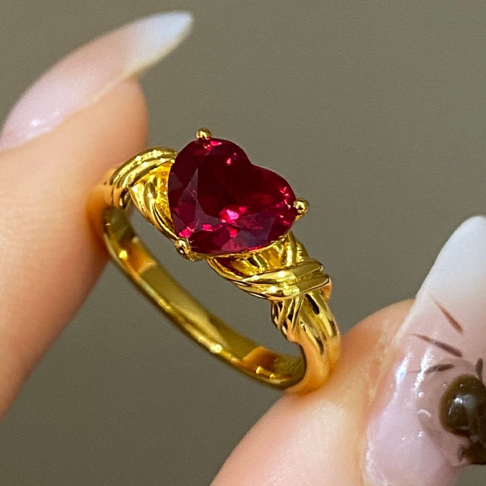 Closeup of 18k heart ring rope-knot detailing and red heart gem