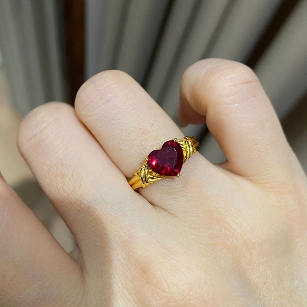 Woman wearing red heart solitaire ring on finger, elegant heart rings for women