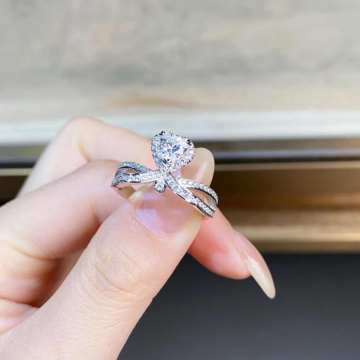 Women’s minimalist heart moissanite ring worn on finger