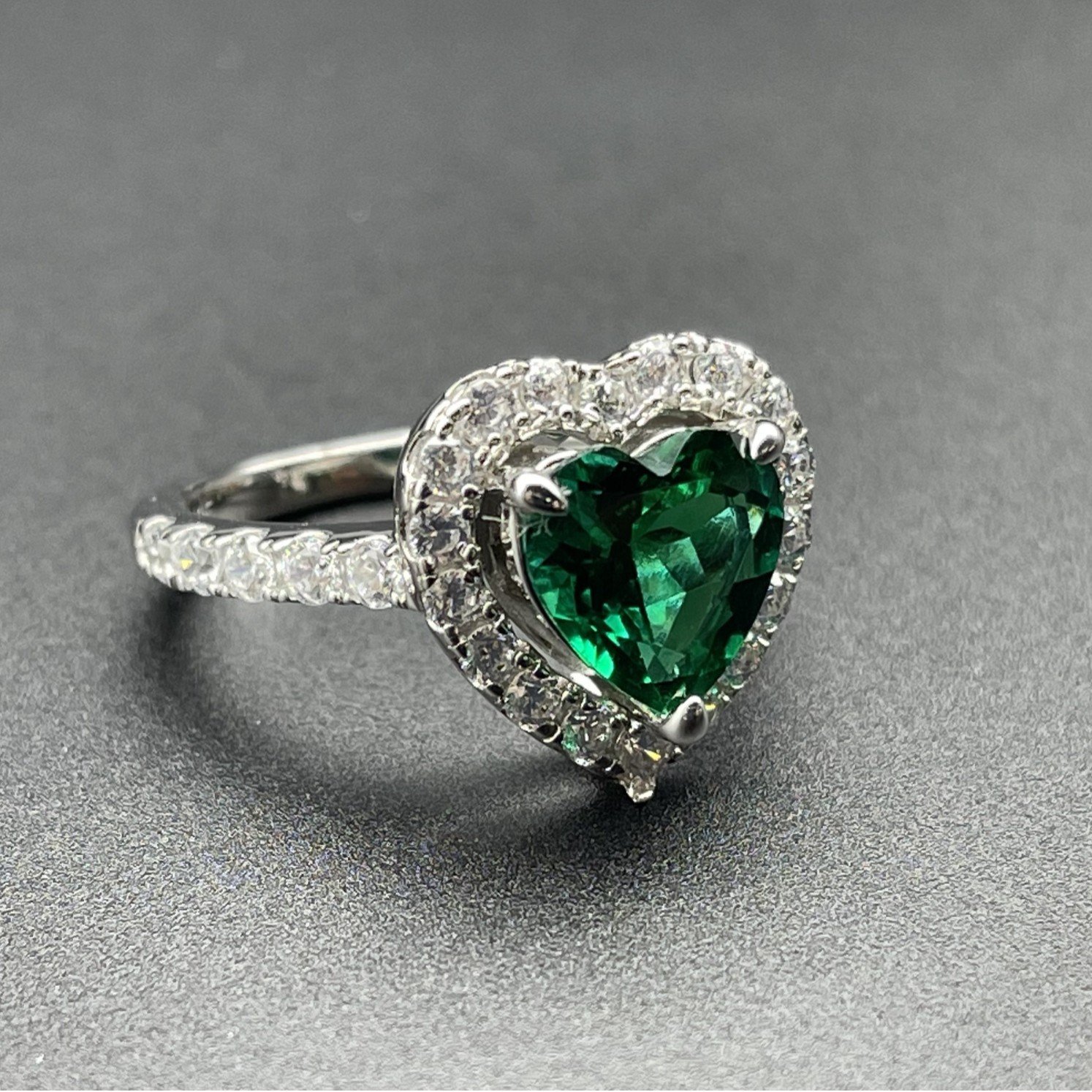 Closeup of emerald heart ring micro-paved cubic zirconia halo details