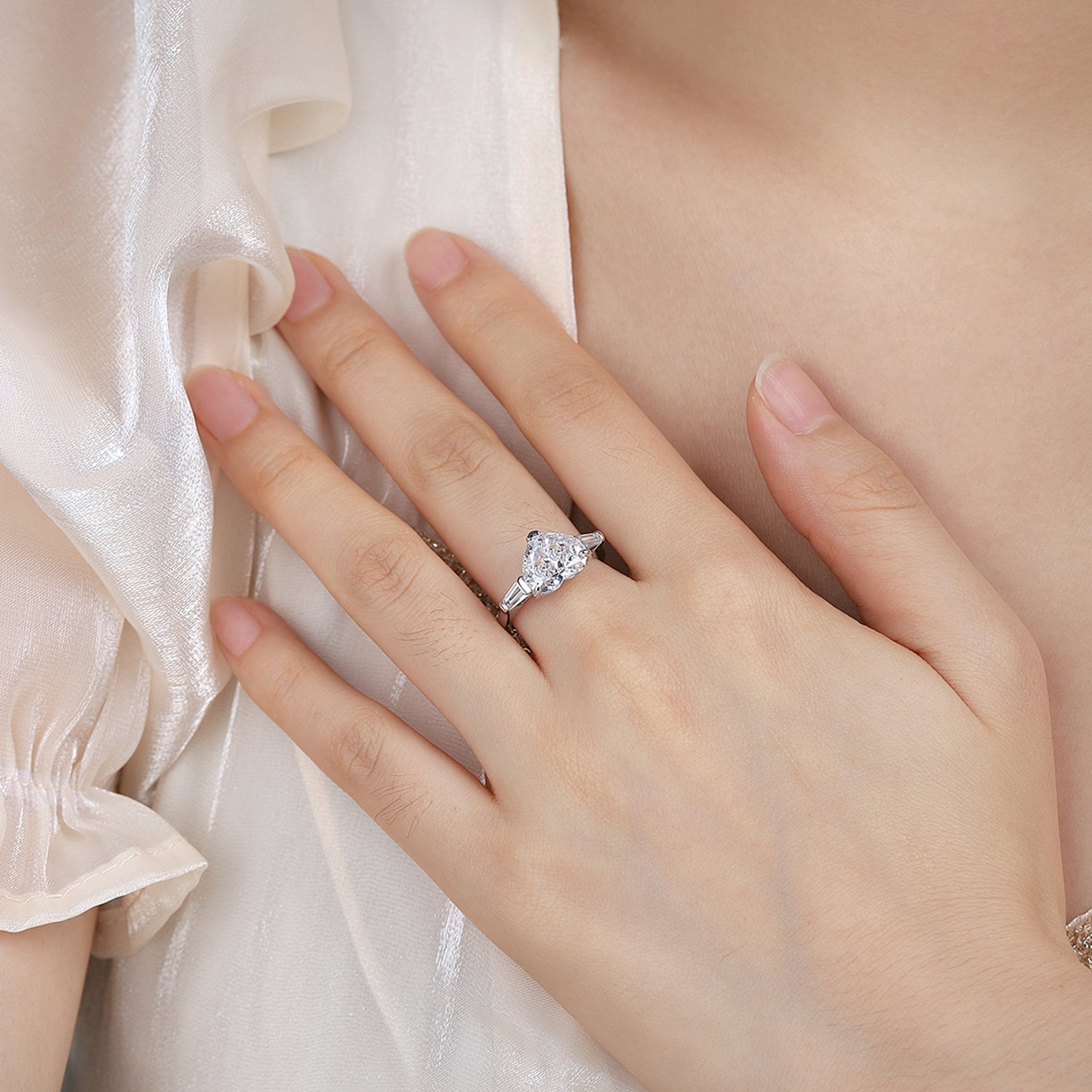 Woman wearing a heart cut solitaire ring, ideal for anniversary gifts.