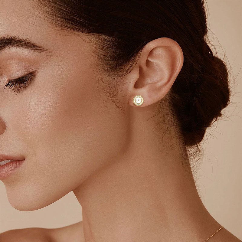 model-wearing-freshwater-pearl-stud-earrings-gold Woman wearing elegant freshwater pearl stud earrings with zirconia halo