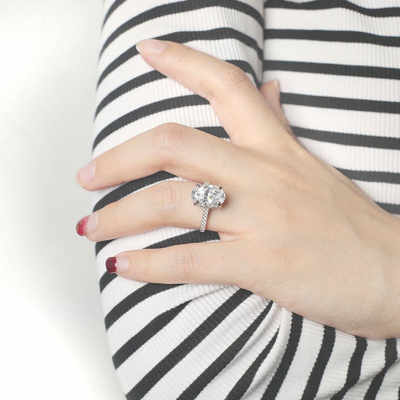 oval-cut-moissanite-ring-on-hand-gift Woman wearing an oval cut moissanite engagement ring, ideal as a wedding or anniversary gift.