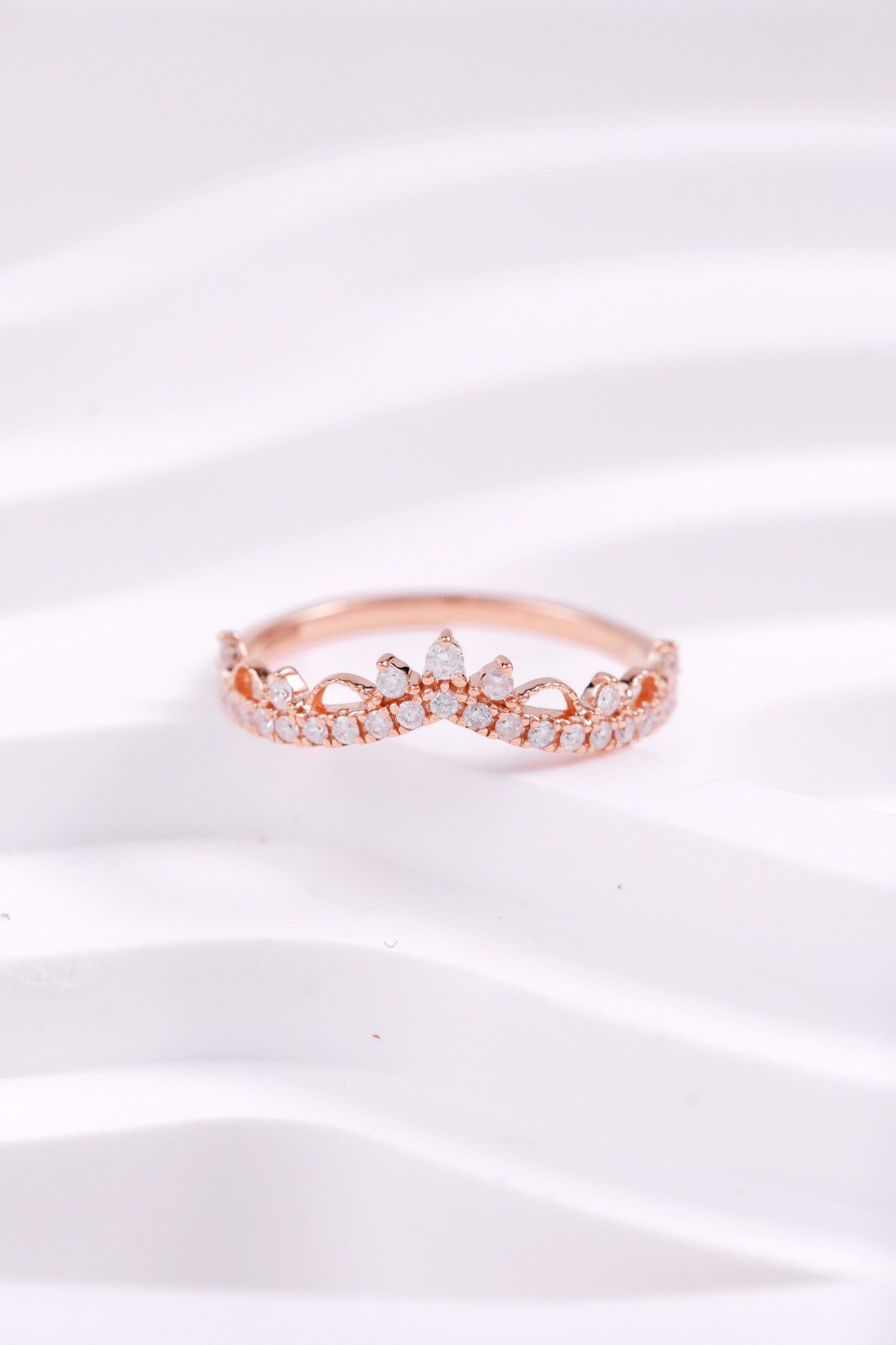 Top view of warm tone rose gold promise ring showcasing crown diamond details