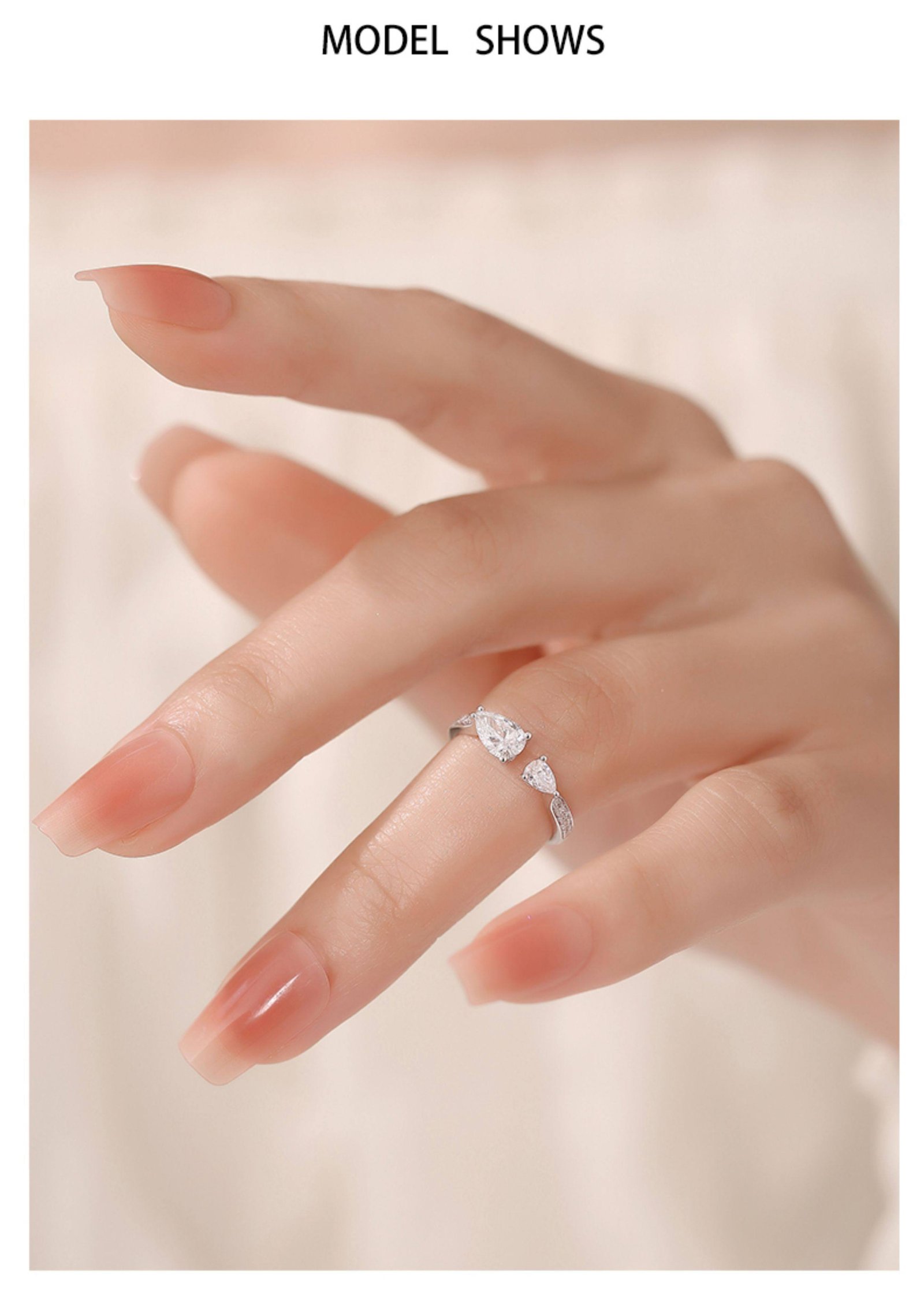 women-wear-toi-et-moi-ring-on-finger Woman wearing toi et moi lab grown diamond ring on finger, showcasing adjustable fit and pear-cut sparkle