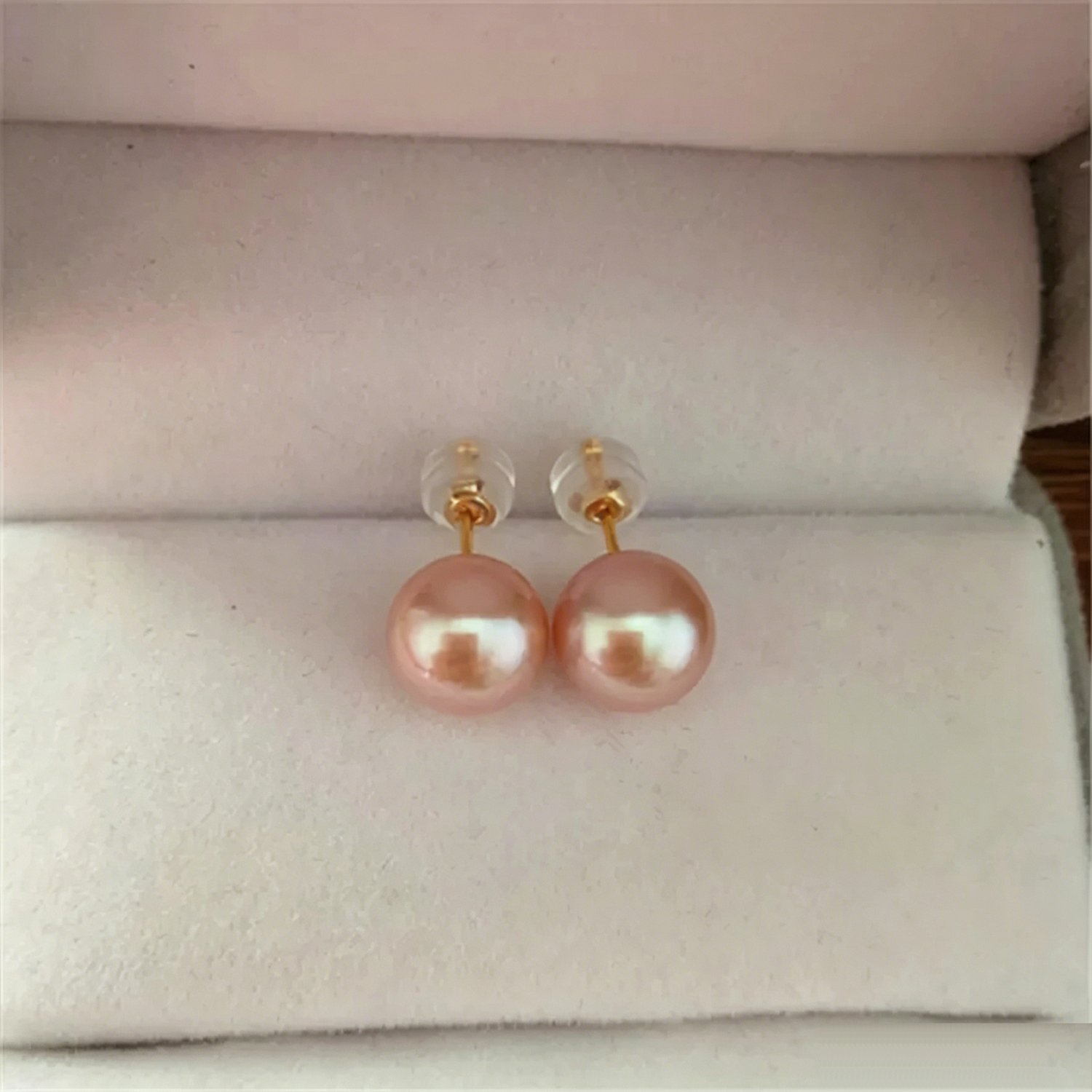 Macro close-up detailing 18K gold ear post and high luster surface of pink freshwater pearl studs