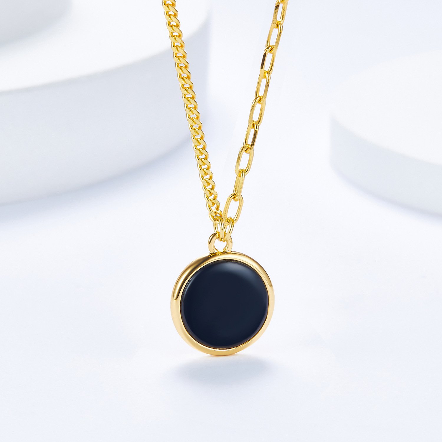 Close-up of polished black onyx surface on reversible round disc pendant