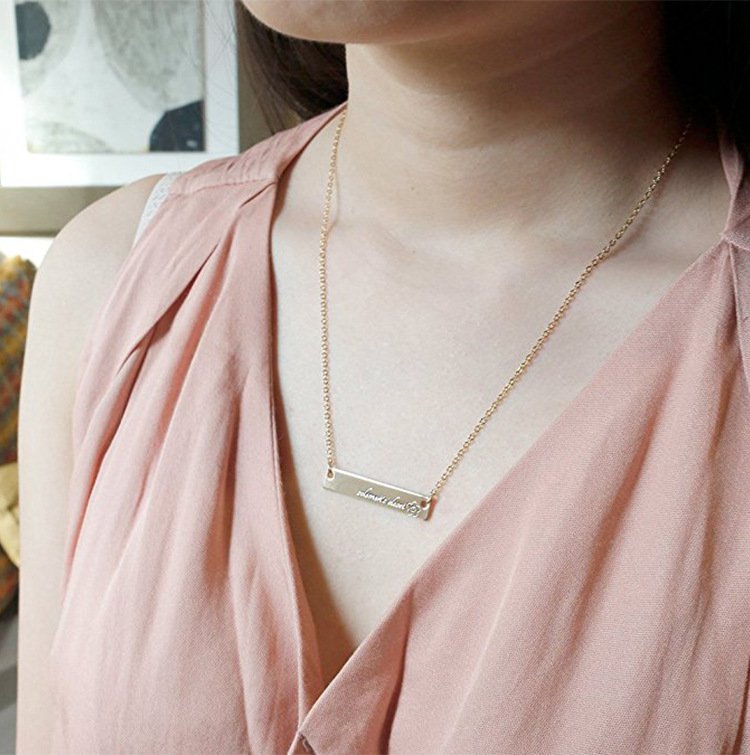 Dainty bar necklace worn alone on neckline, minimalist silver design with smooth polished finish.