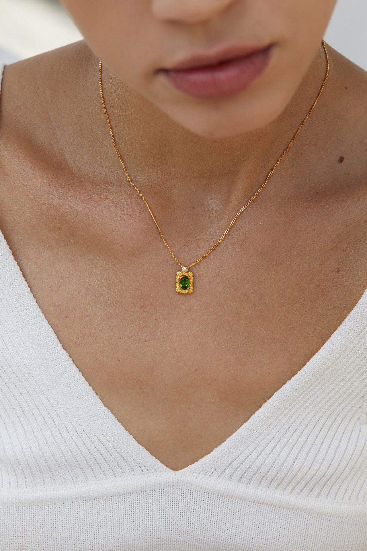 Girl wearing minimalist textured square diopside pendant necklace for office commute outfit