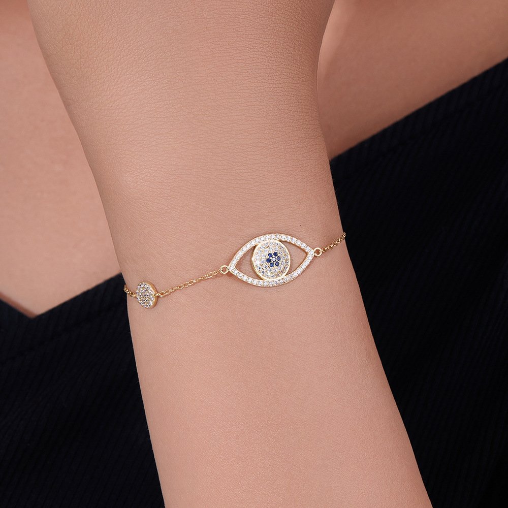 Women daily wearing SYMARA 18k gold evil eye stackable bracelet