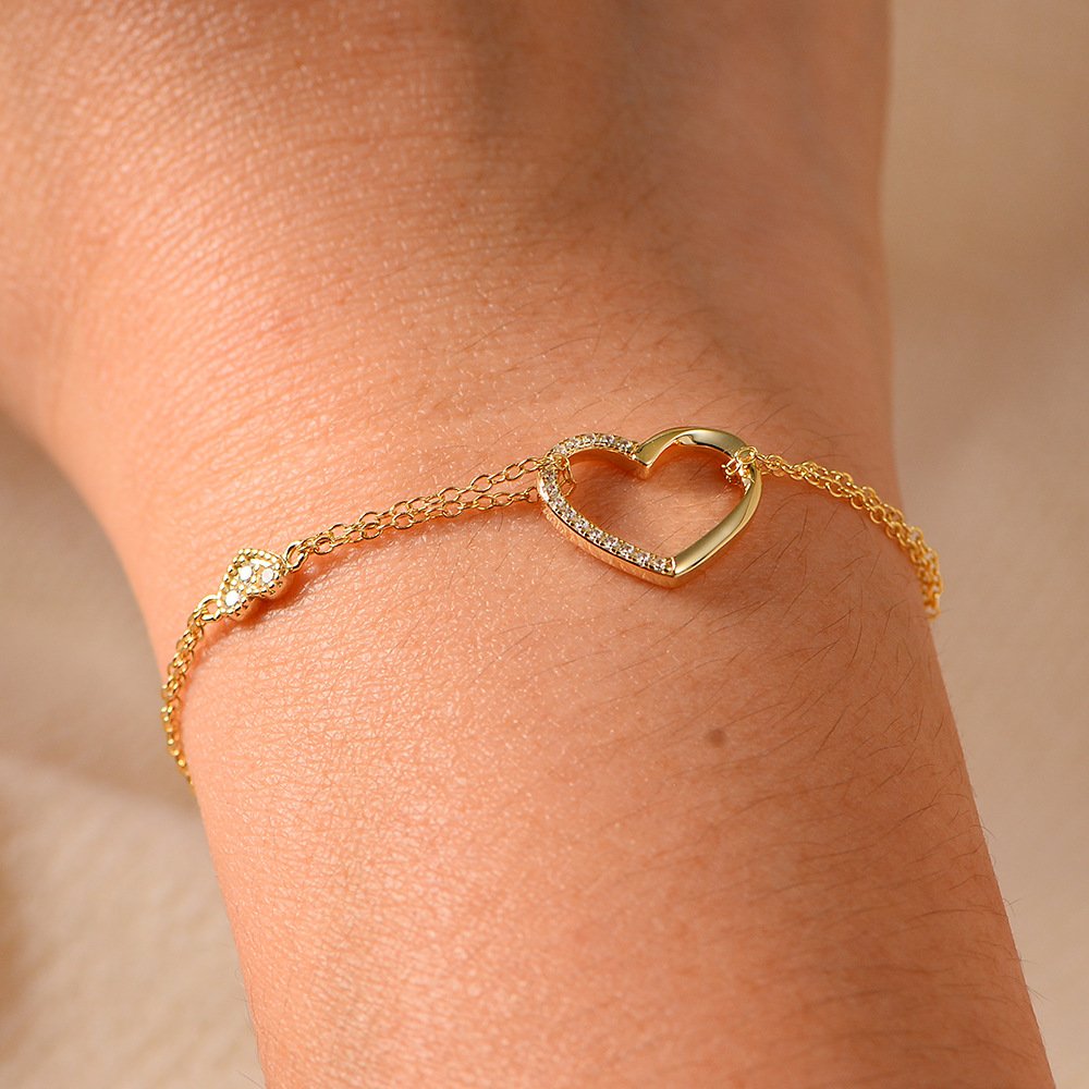 Wrist close-up of 18k white gold two-heart cubic zirconia bracelet, 925 sterling silver graduation formal wear mom daughter jewelry