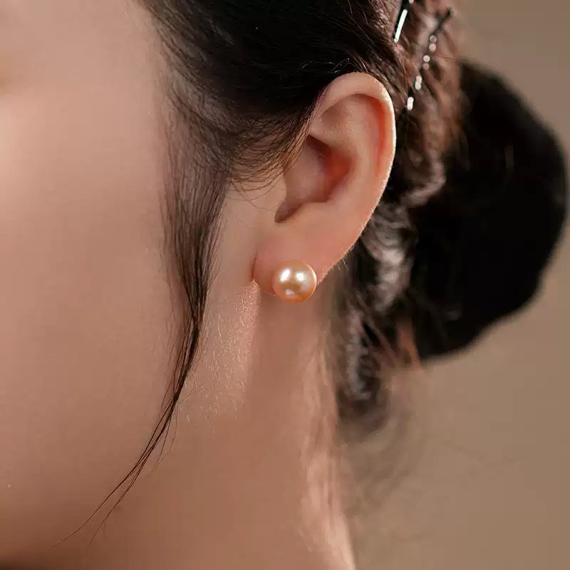 Middle-aged mom wearing peach pearl studs received as Mother’s Day fine jewelry gift