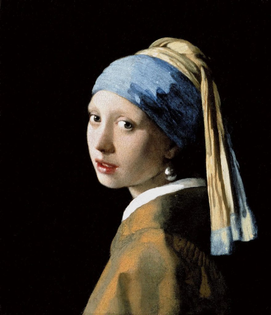 Close-up detail of the pearl earring in Vermeer's Girl with a Pearl Earring, revealing the bright white highlight and the soft reflection of the collar below