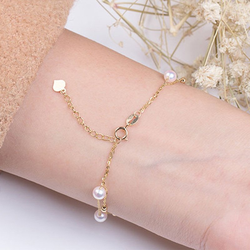 Woman wearing AU750 18K gold double‑layer starry pearl bracelet showing soft winding wrist look