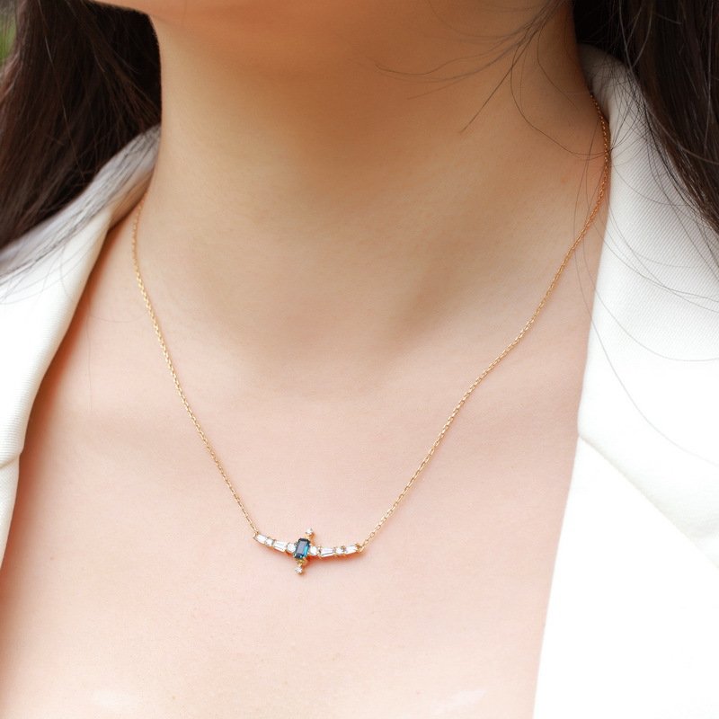 Close-up of 3×5mm emerald-cut London blue topaz, showing rich deep blue hue and faceted sparkle