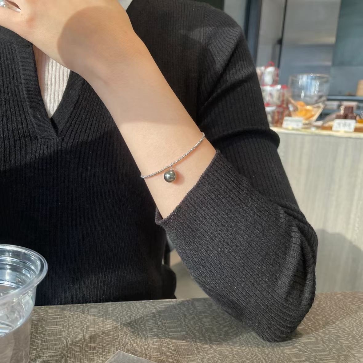 Minimalist Tahitian pearl bangle worn on wrist, adjustable S925 silver twisted bead design for formal events