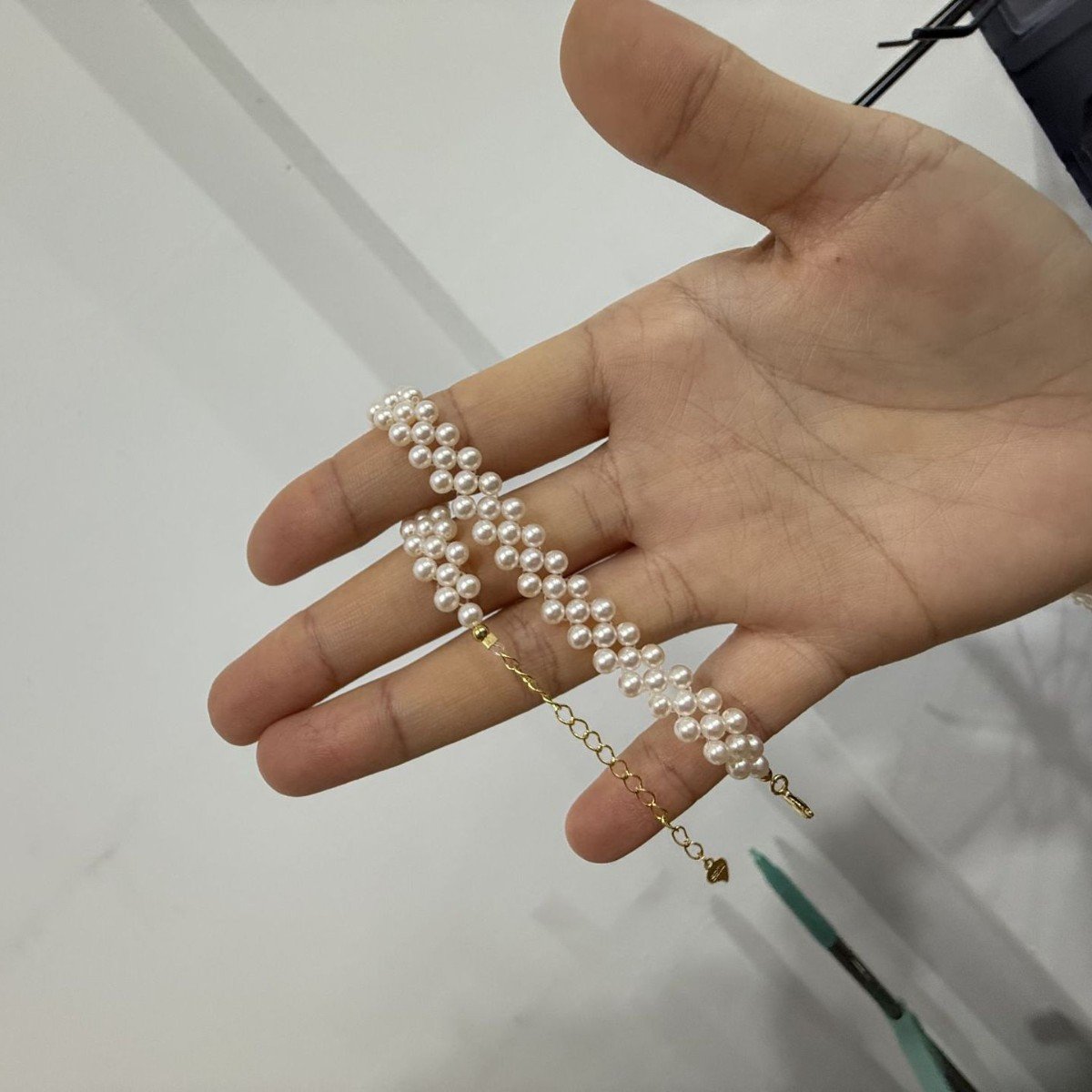 Close-up of S925 sterling silver clasp and adjustable extender chain on a hand-woven freshwater pearl bracelet, fine artisan jewelry detail for women.