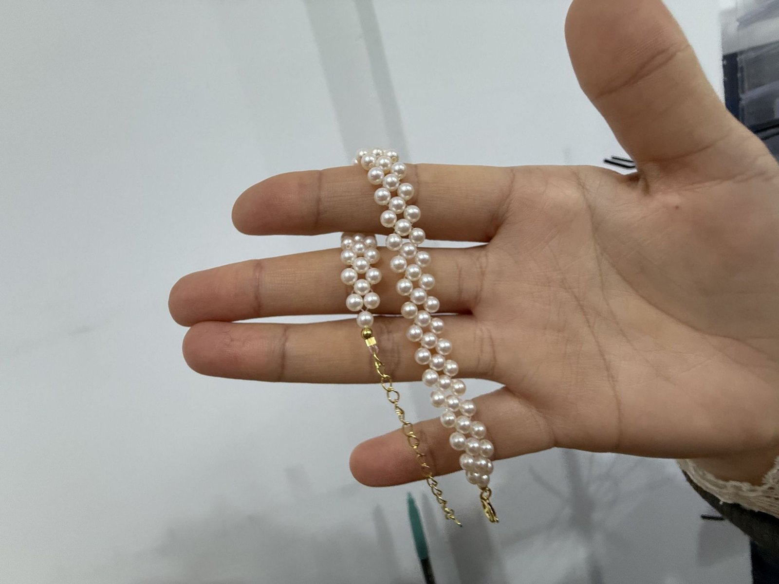 Close-up of S925 sterling silver clasp and adjustable extender chain on a hand-woven freshwater pearl bracelet, fine artisan jewelry detail for women.